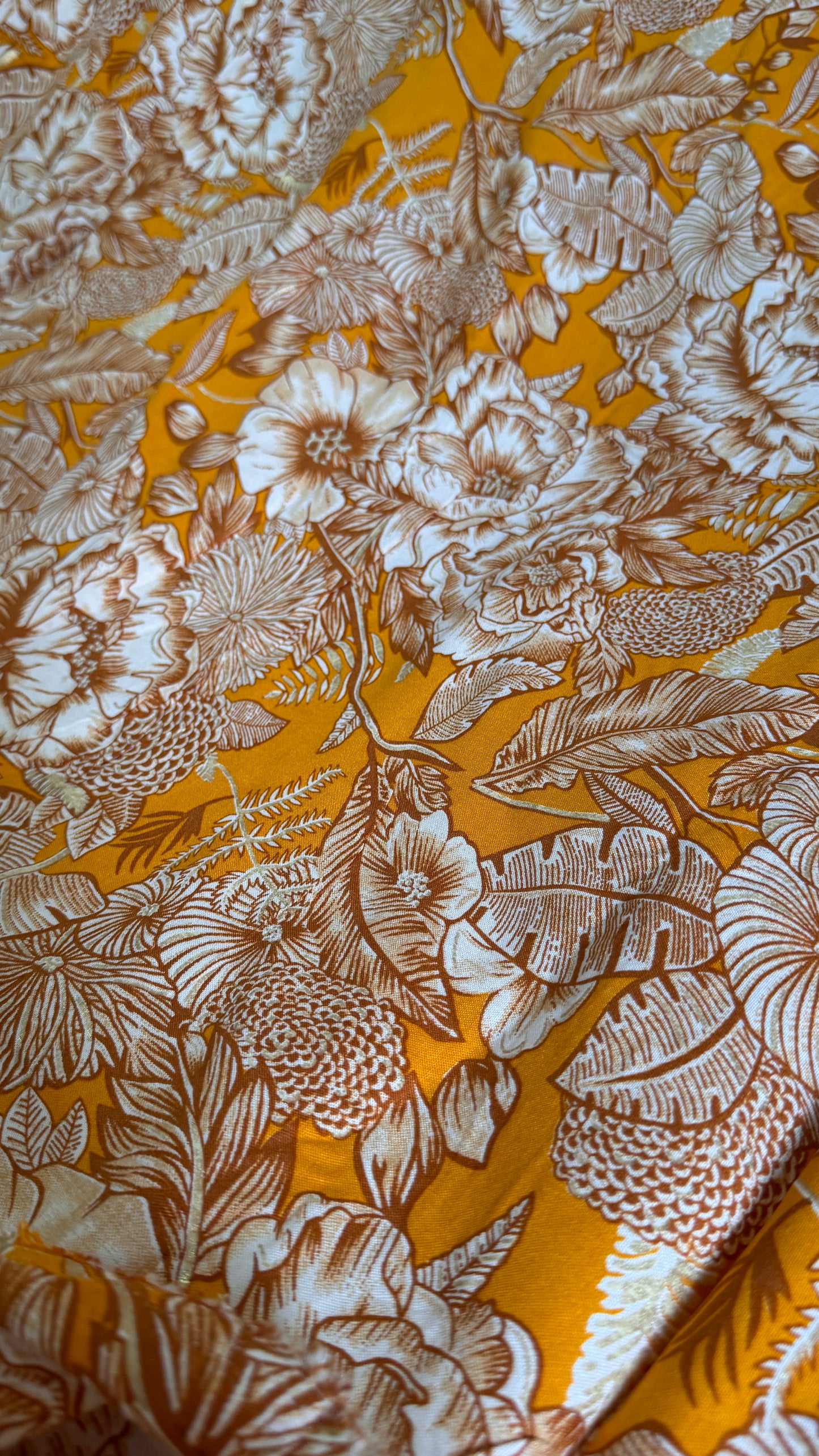 Floral patterned fabric with brown flowers on a yellow background