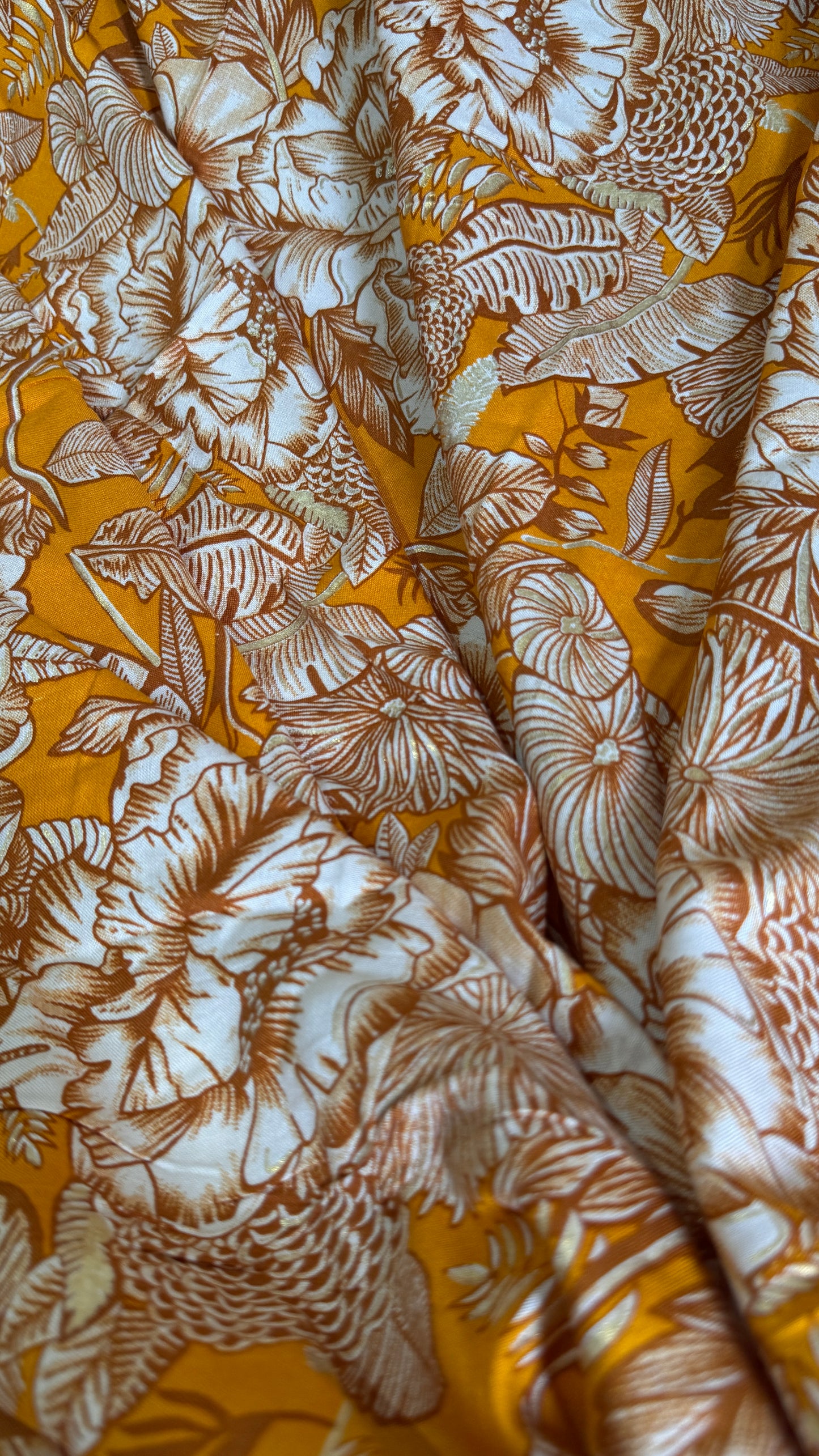 Close-up of fabric with brown floral pattern on a yellow background