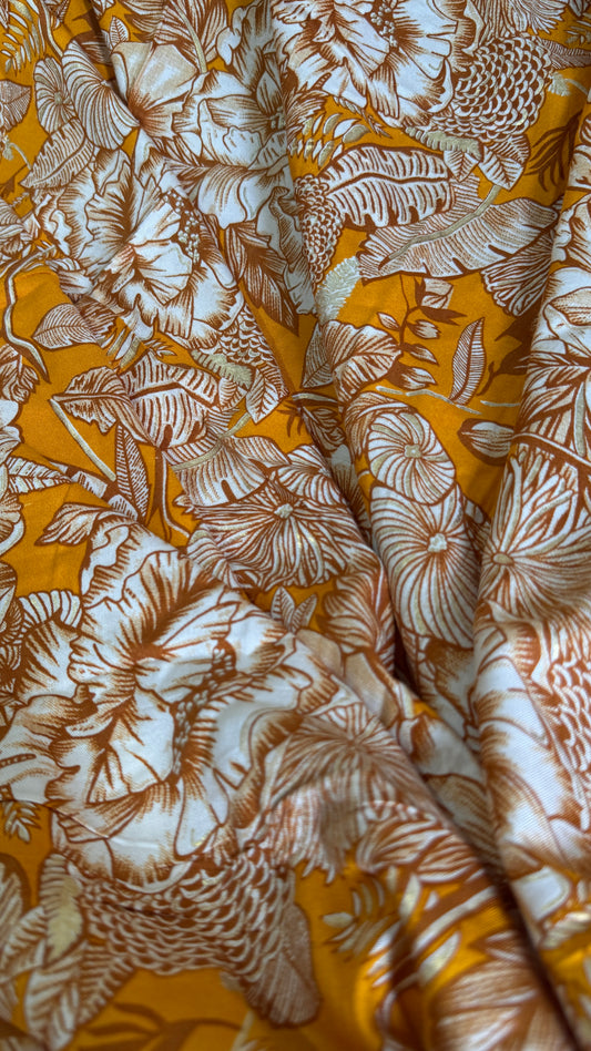 Close-up of fabric with brown floral pattern on a yellow background