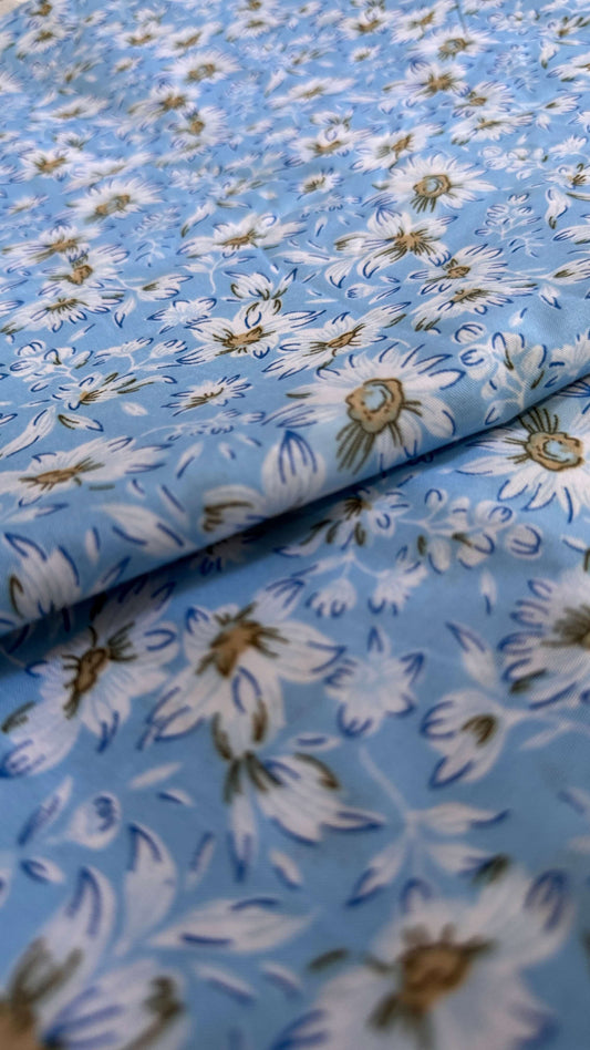 Floral fabric pattern with white flowers on a blue background