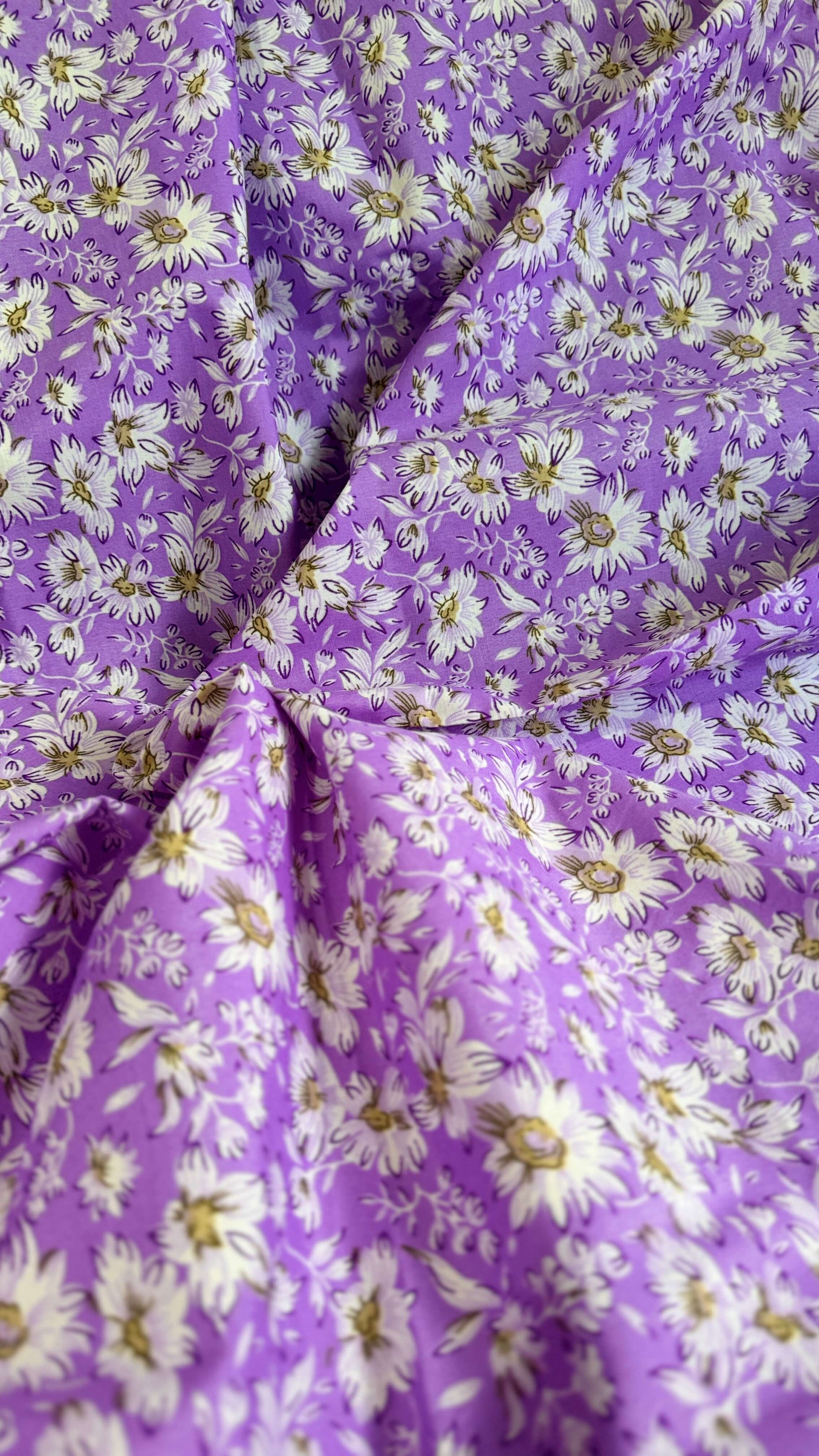 Close-up of purple fabric with white floral pattern