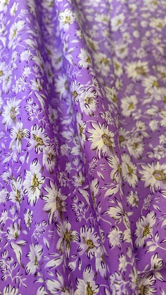 Floral fabric with white flowers on a purple background