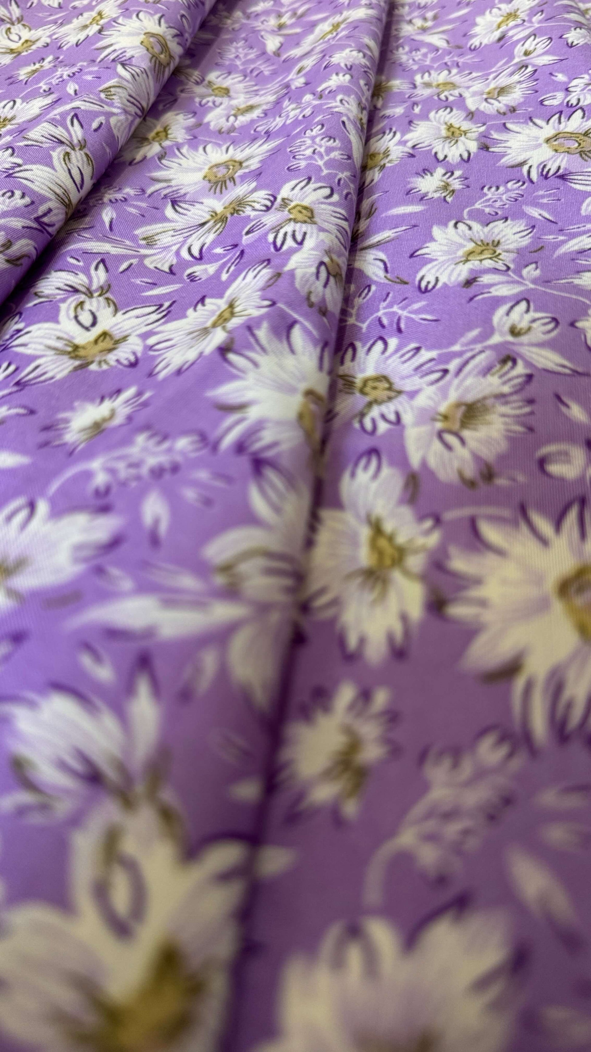 Floral fabric with white flowers on a purple background
