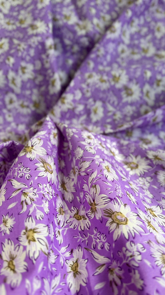 Close-up of purple fabric with white floral pattern