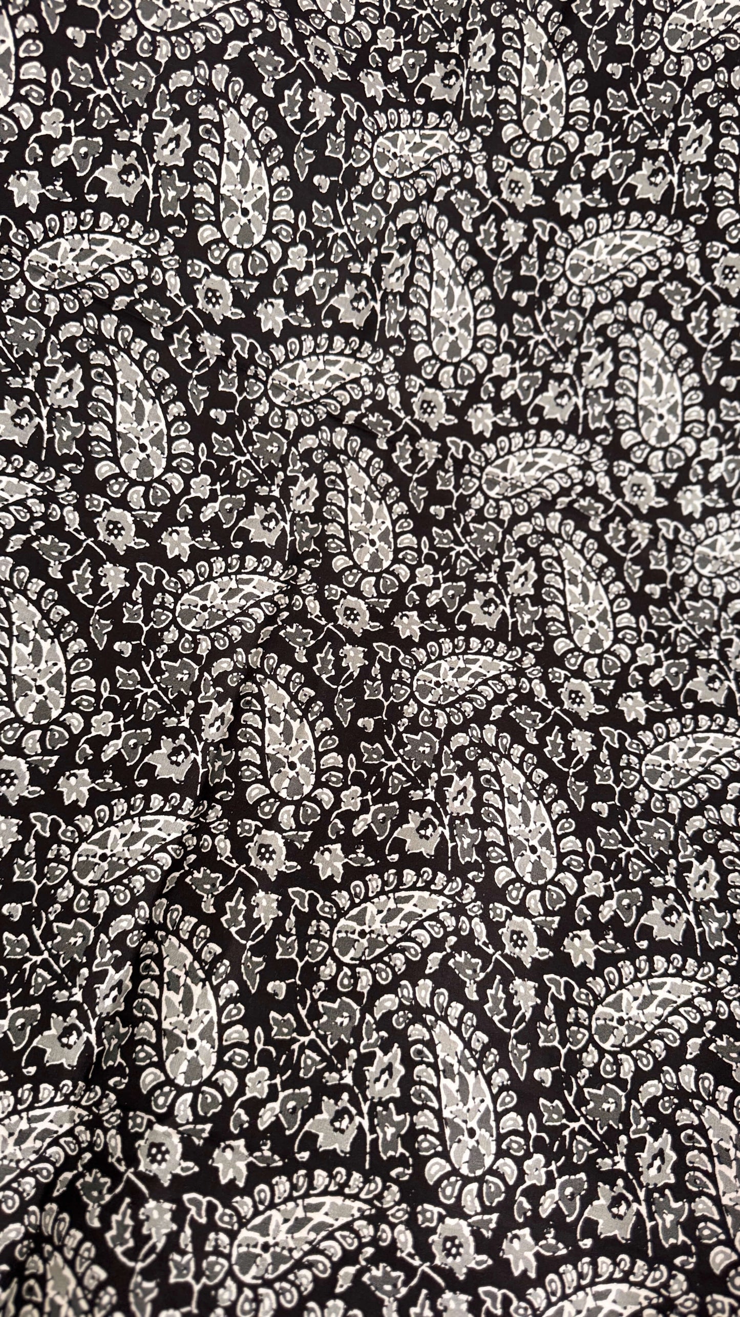 Black and white paisley pattern on a textured background