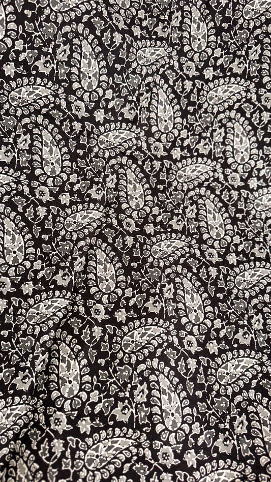 Black and white paisley pattern on a textured background