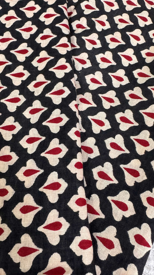 Patterned fabric with red and beige shapes on a black background