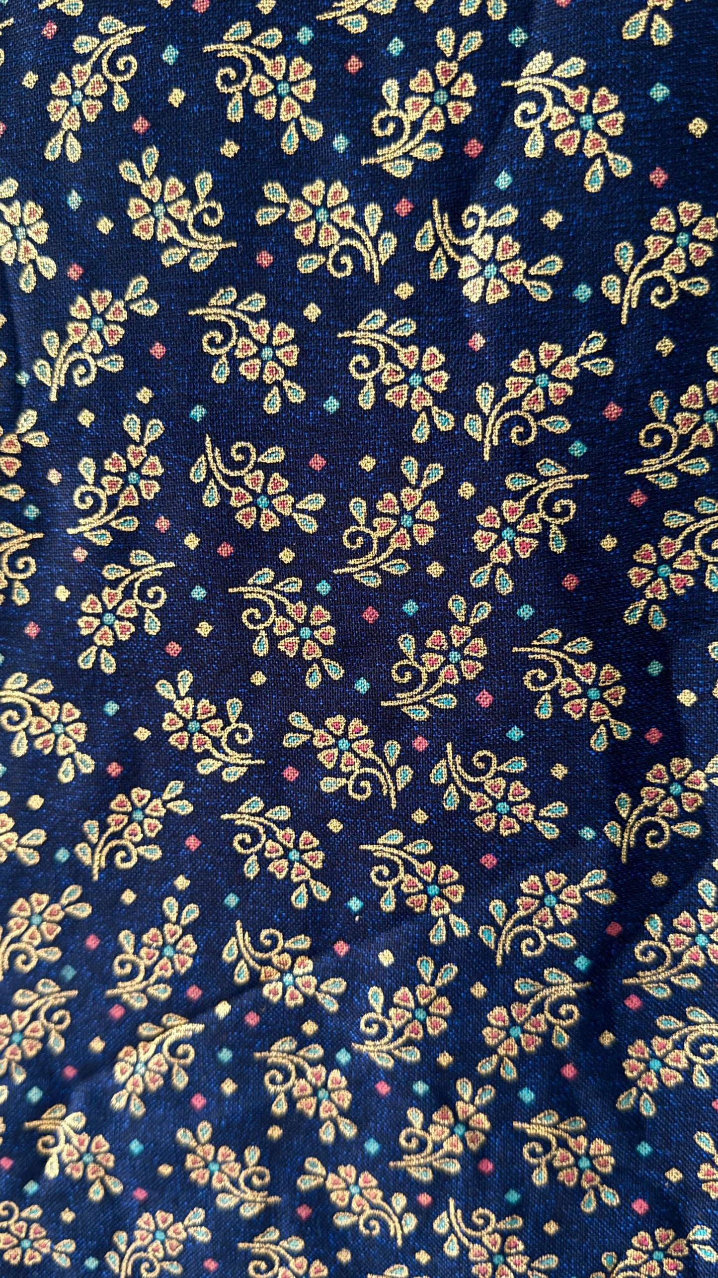 Navy blue fabric with small floral patterns in gold, pink, and white.