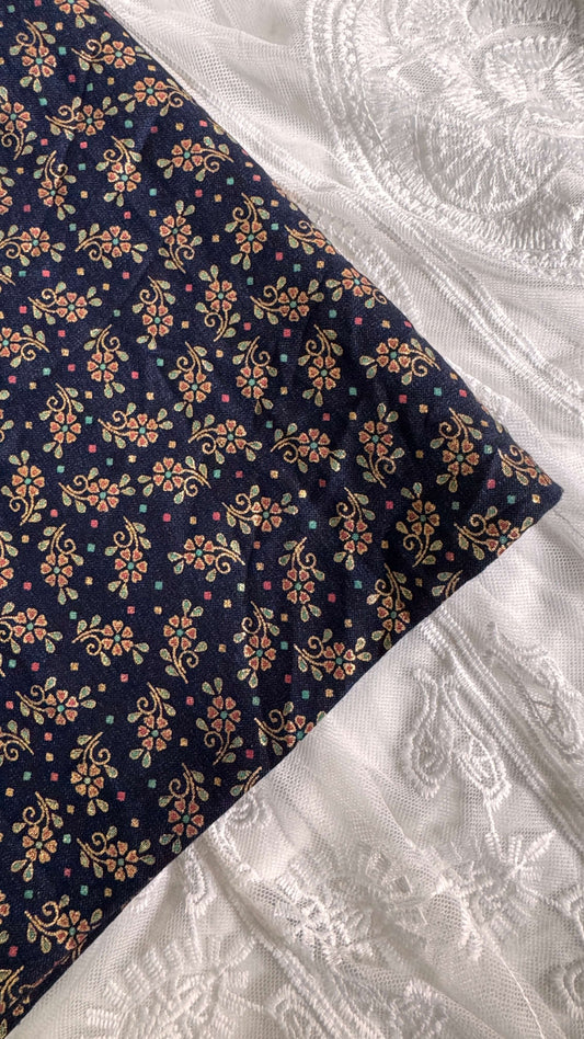 Navy fabric with floral pattern on a white embroidered fabric background