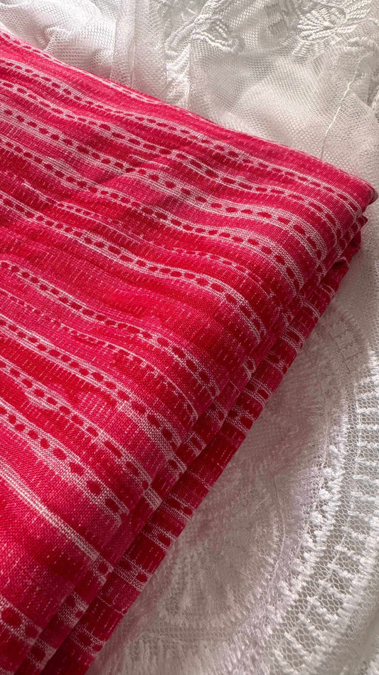 Red fabric with white patterns on a textured white background
