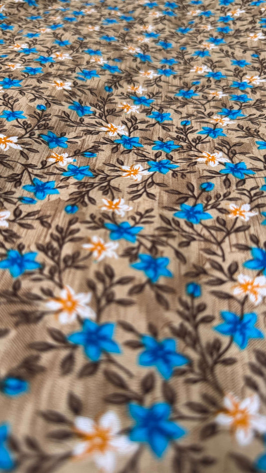 Close-up of fabric with blue and white floral pattern on brown background