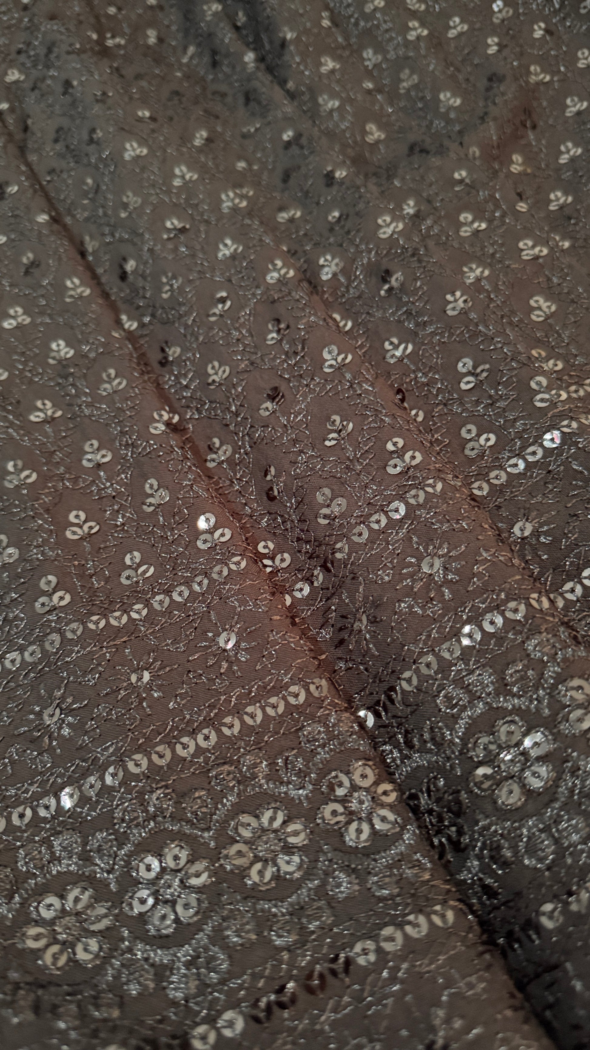 Close-up of a textured fabric with floral patterns and a dark background