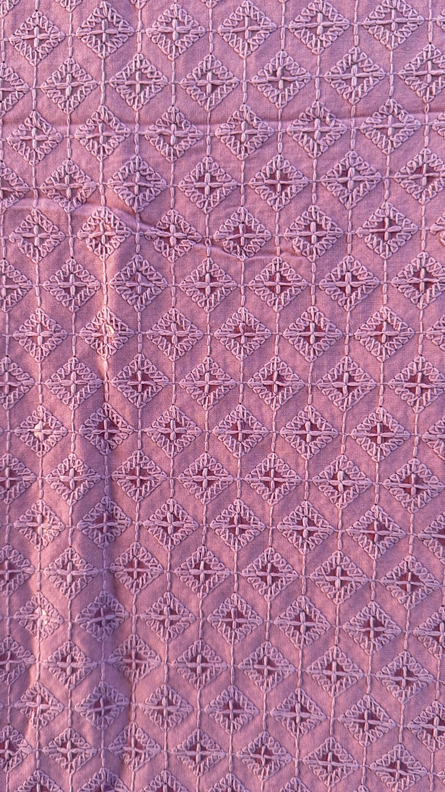 Patterned fabric with a diamond grid design in shades of purple.