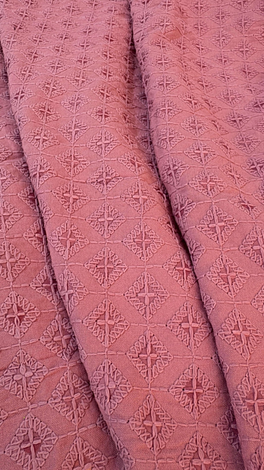 Close-up of pink textured fabric with geometric pattern