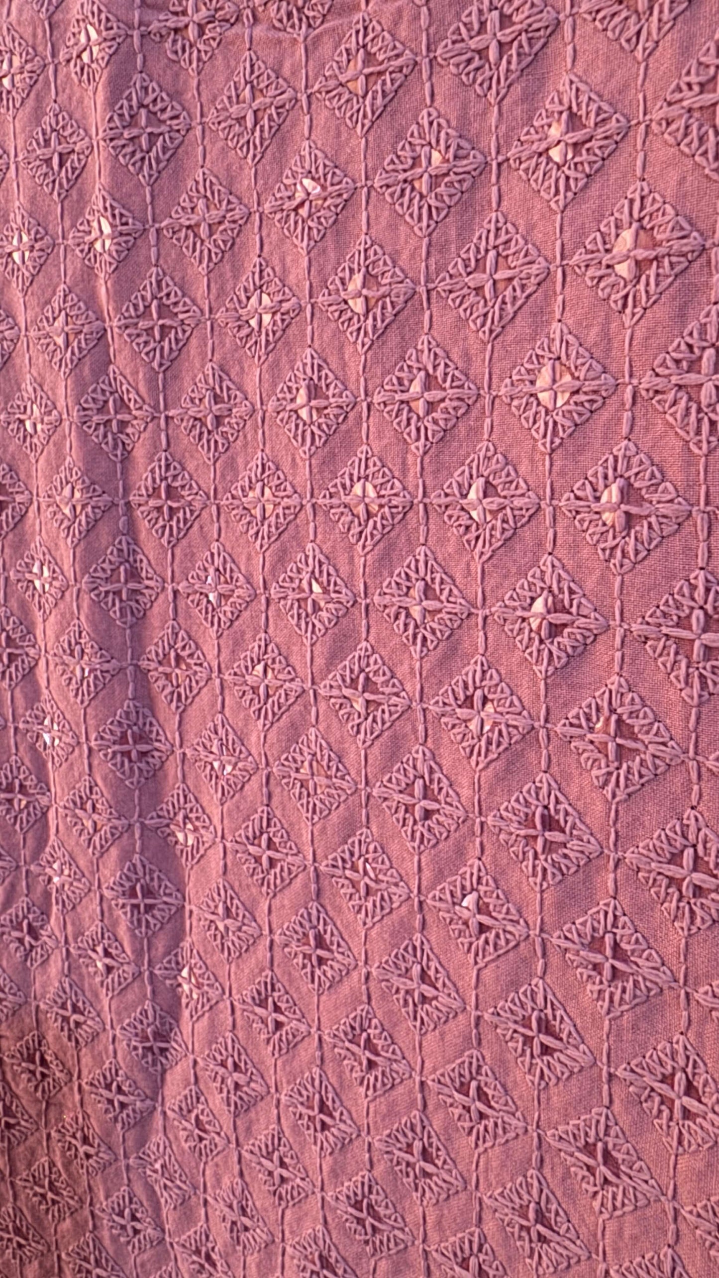 Close-up of a textured pink fabric with geometric patterns
