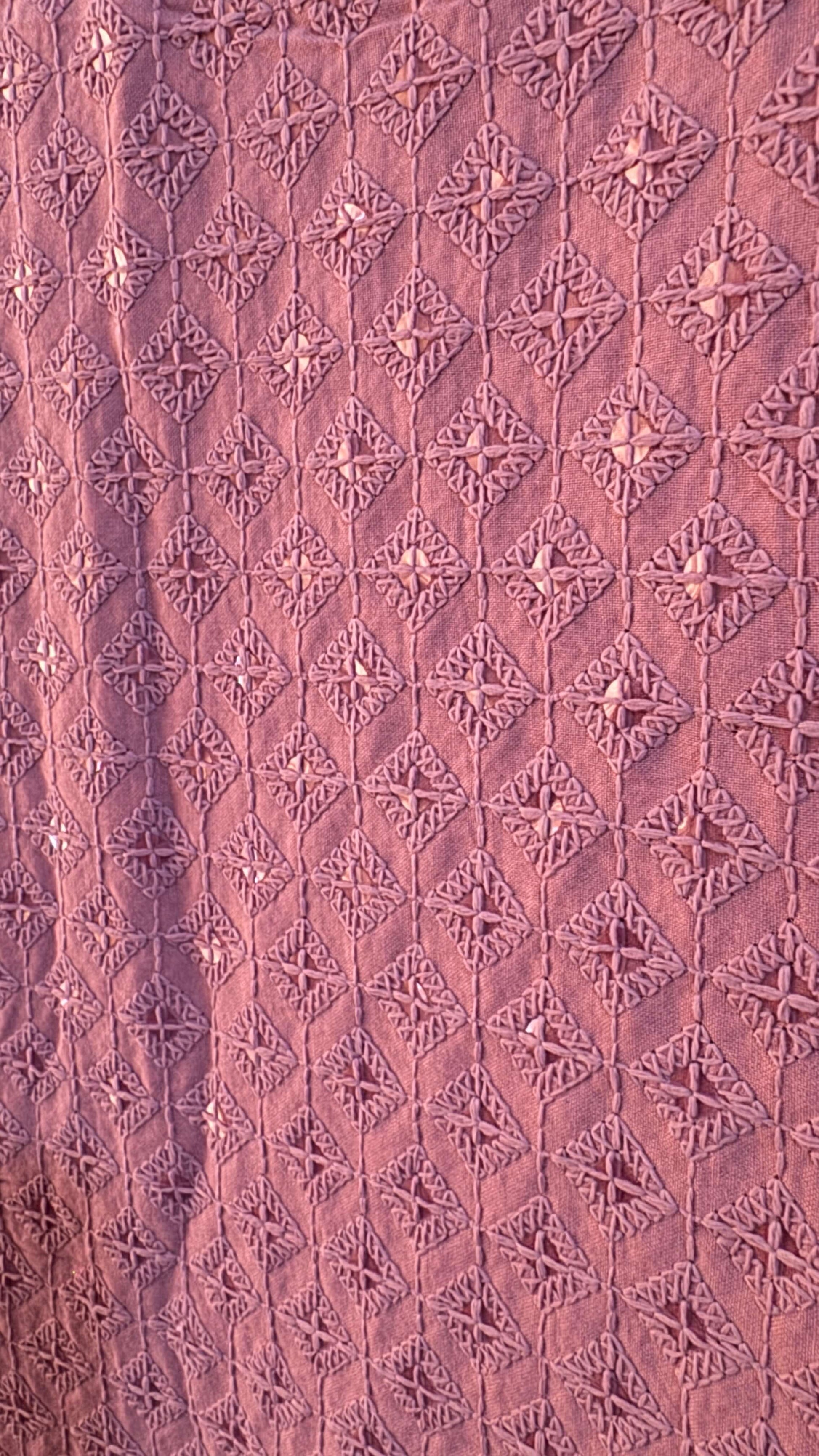 Close-up of a textured pink fabric with geometric patterns