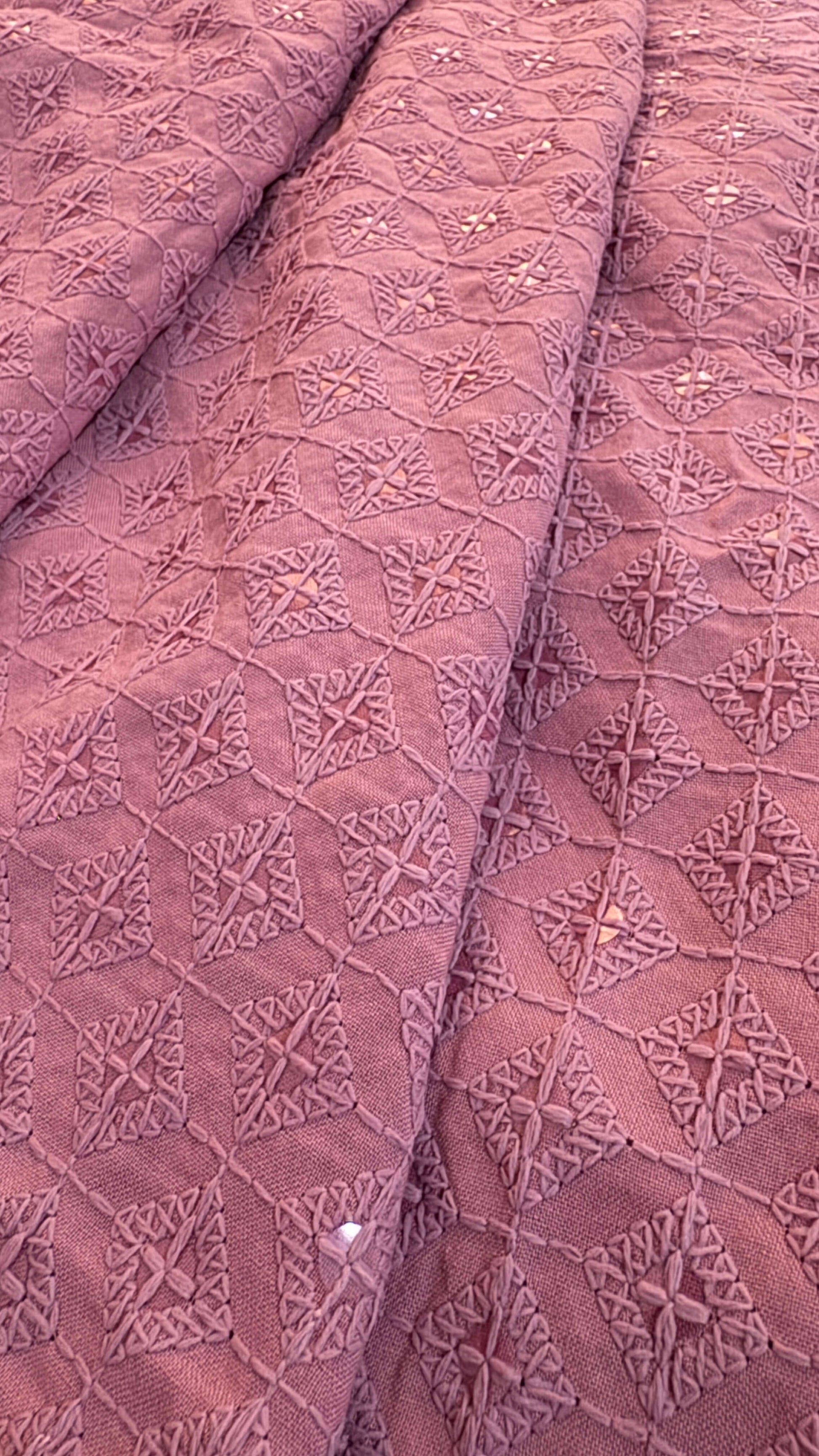 Close-up of textured pink fabric with geometric pattern