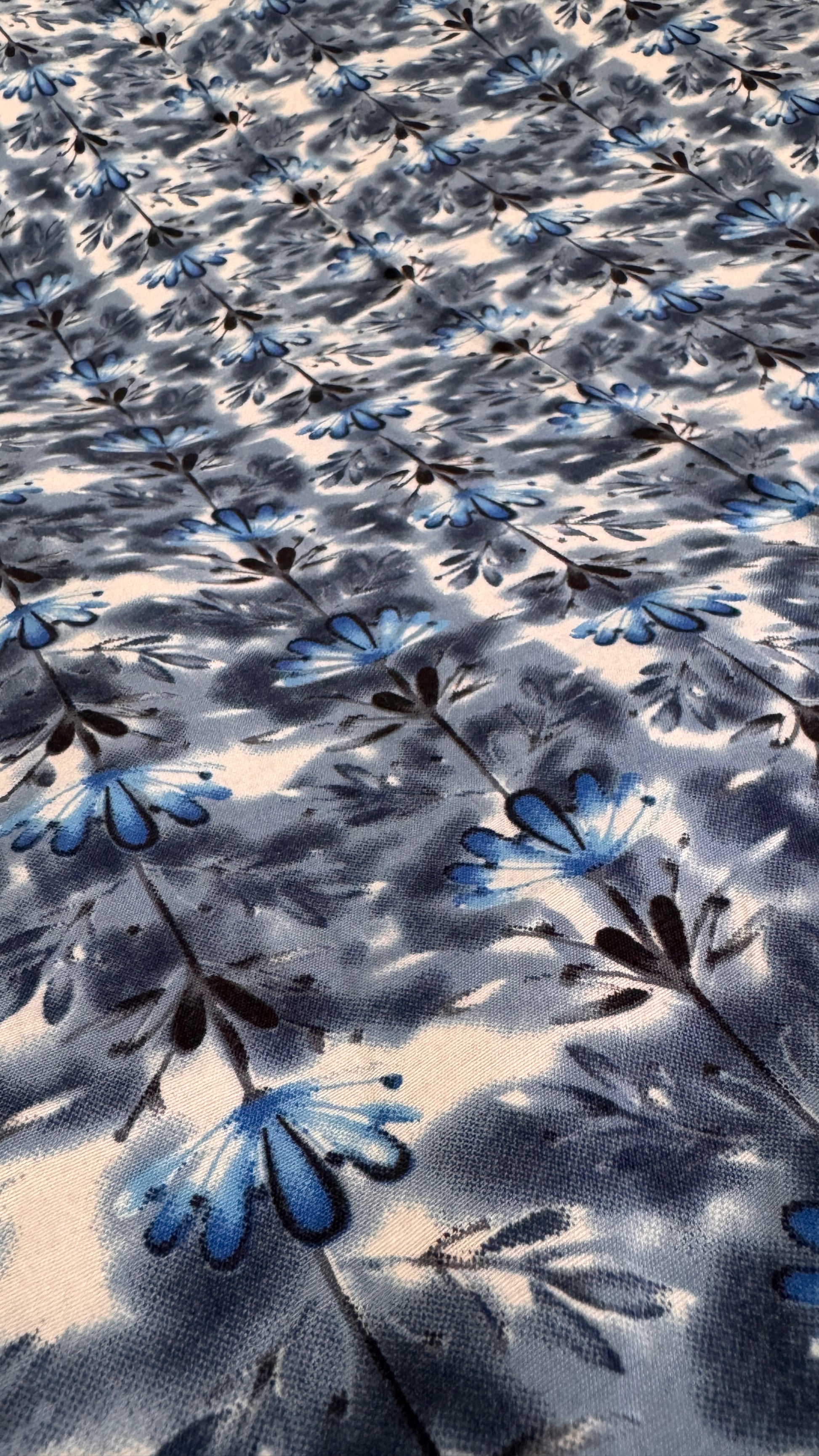 Floral patterned fabric with blue and black flowers on a light background