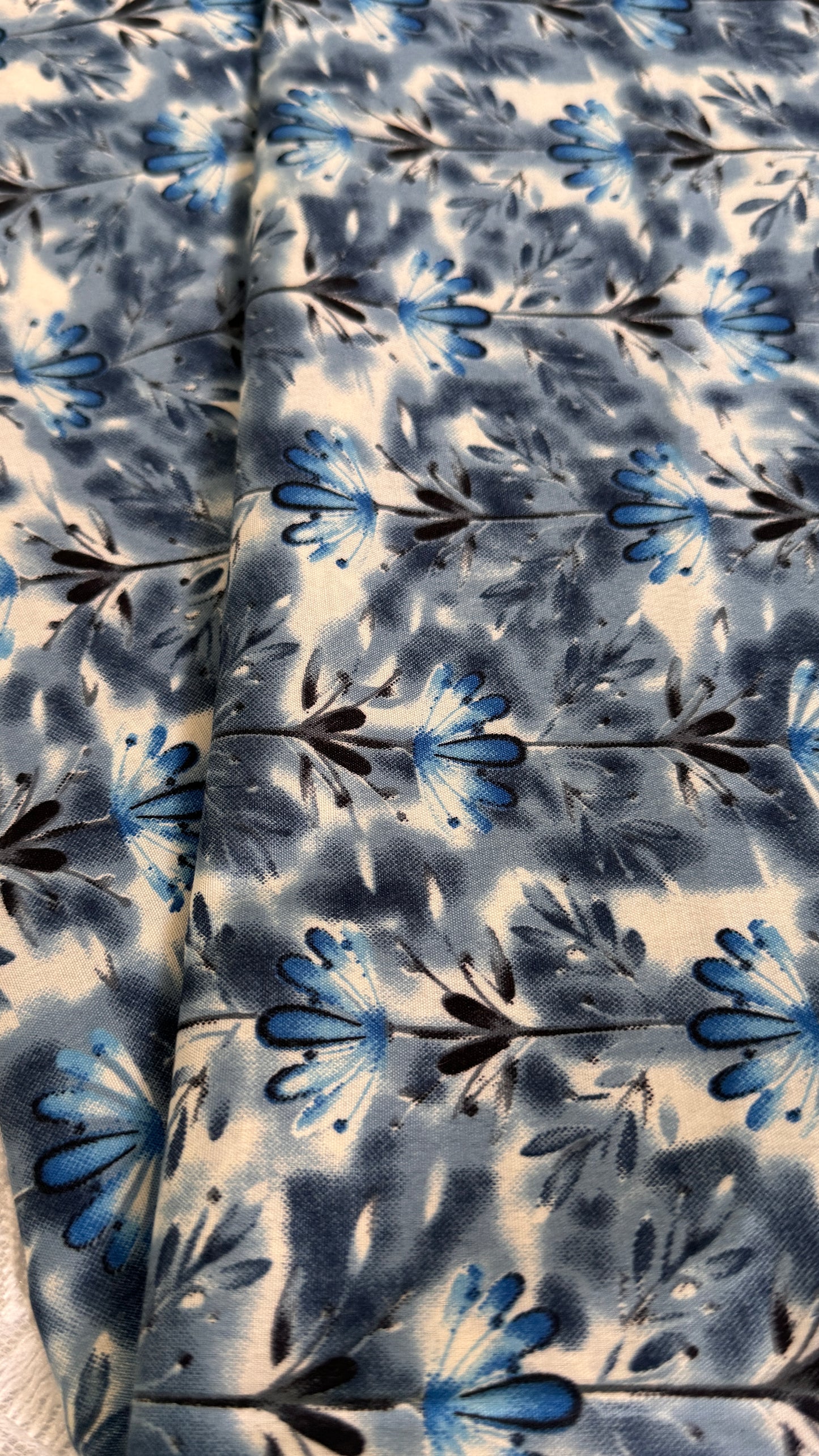 Floral patterned fabric with blue and black flowers on a white background