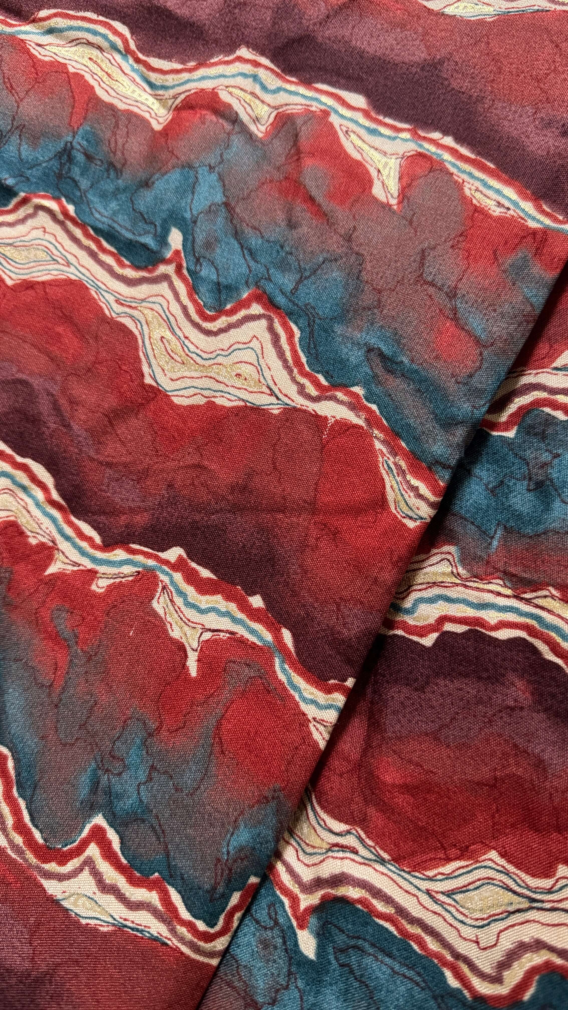 Close-up of a fabric with red, blue, and beige wavy pattern
