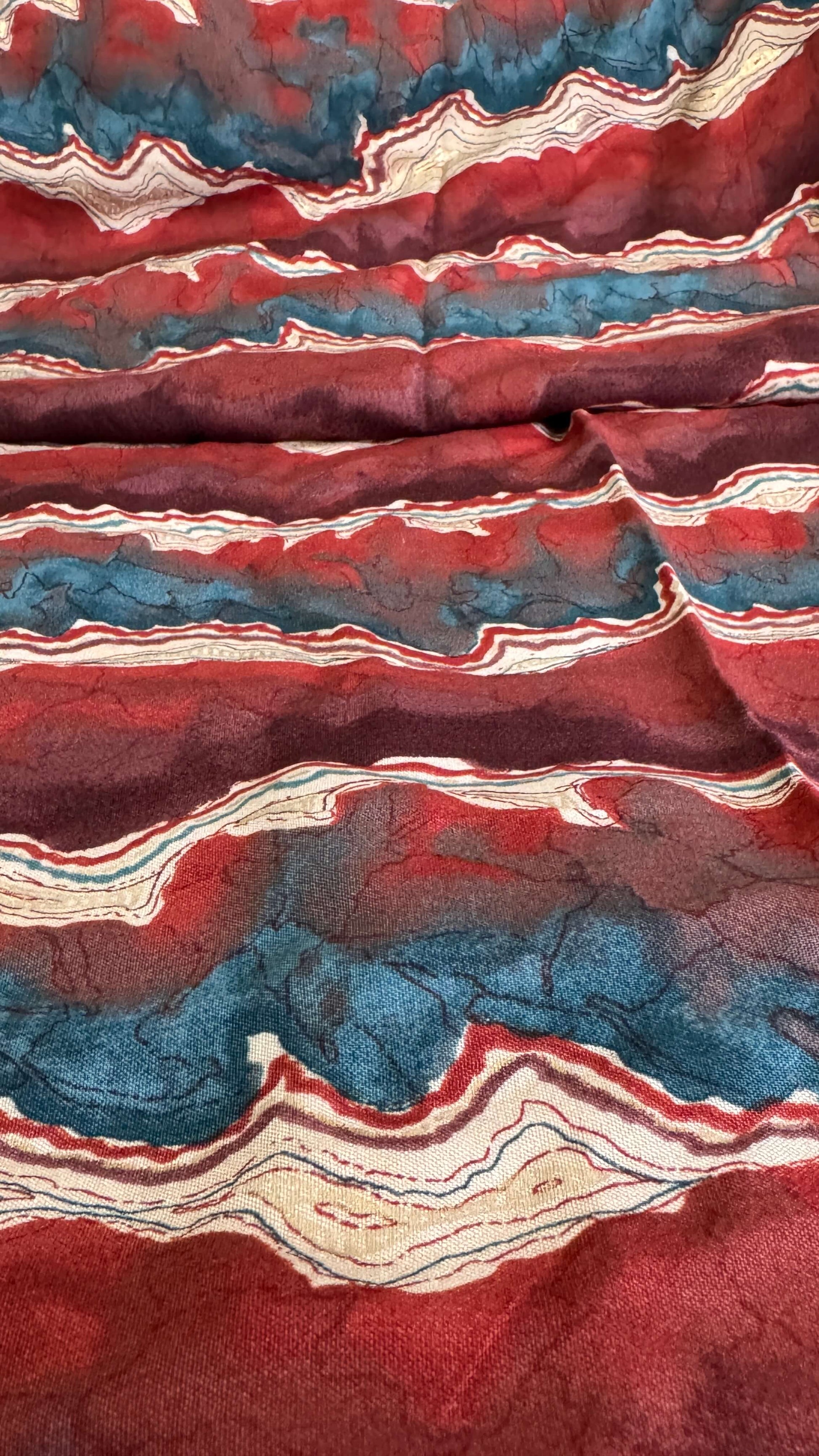 Close-up of a textured fabric with red, blue, and beige patterns