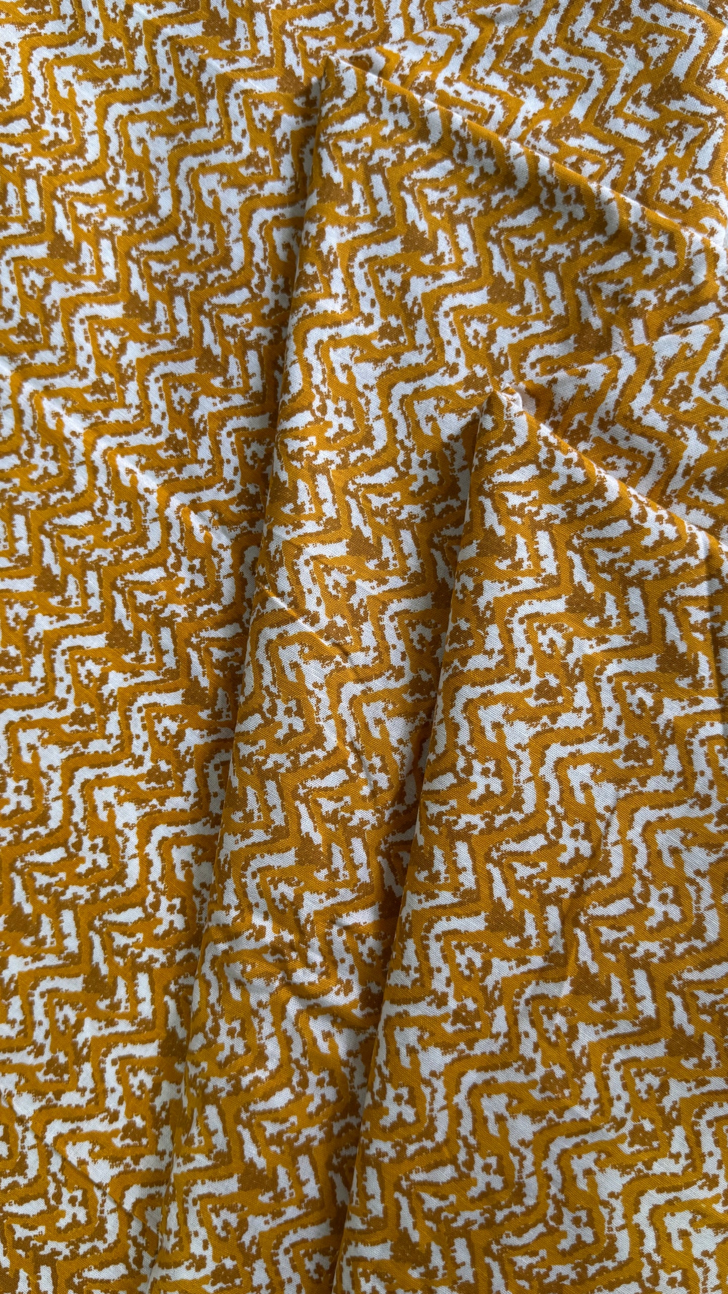 Close-up of fabric with a yellow and white geometric pattern