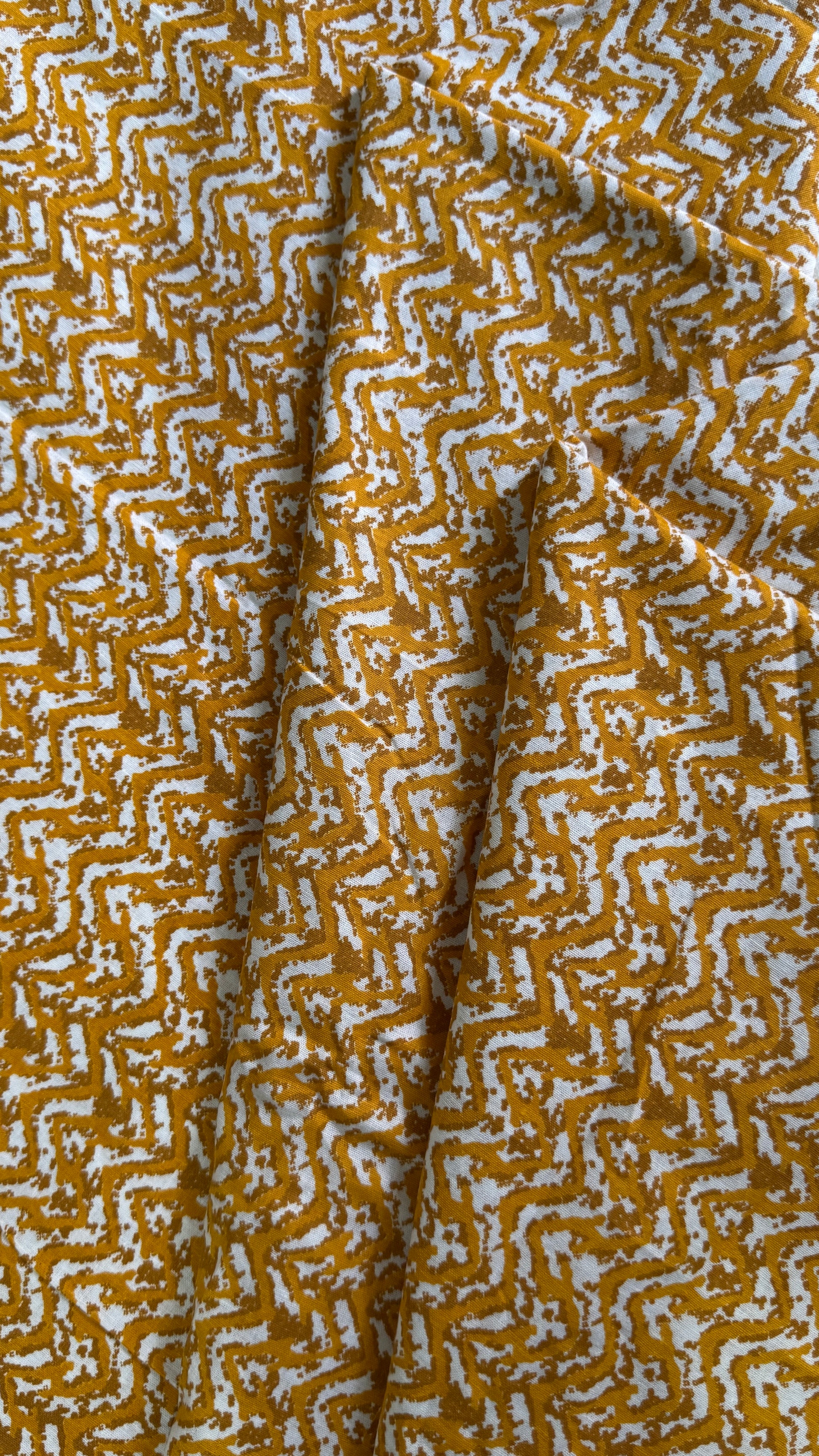 Close-up of fabric with a yellow and white geometric pattern