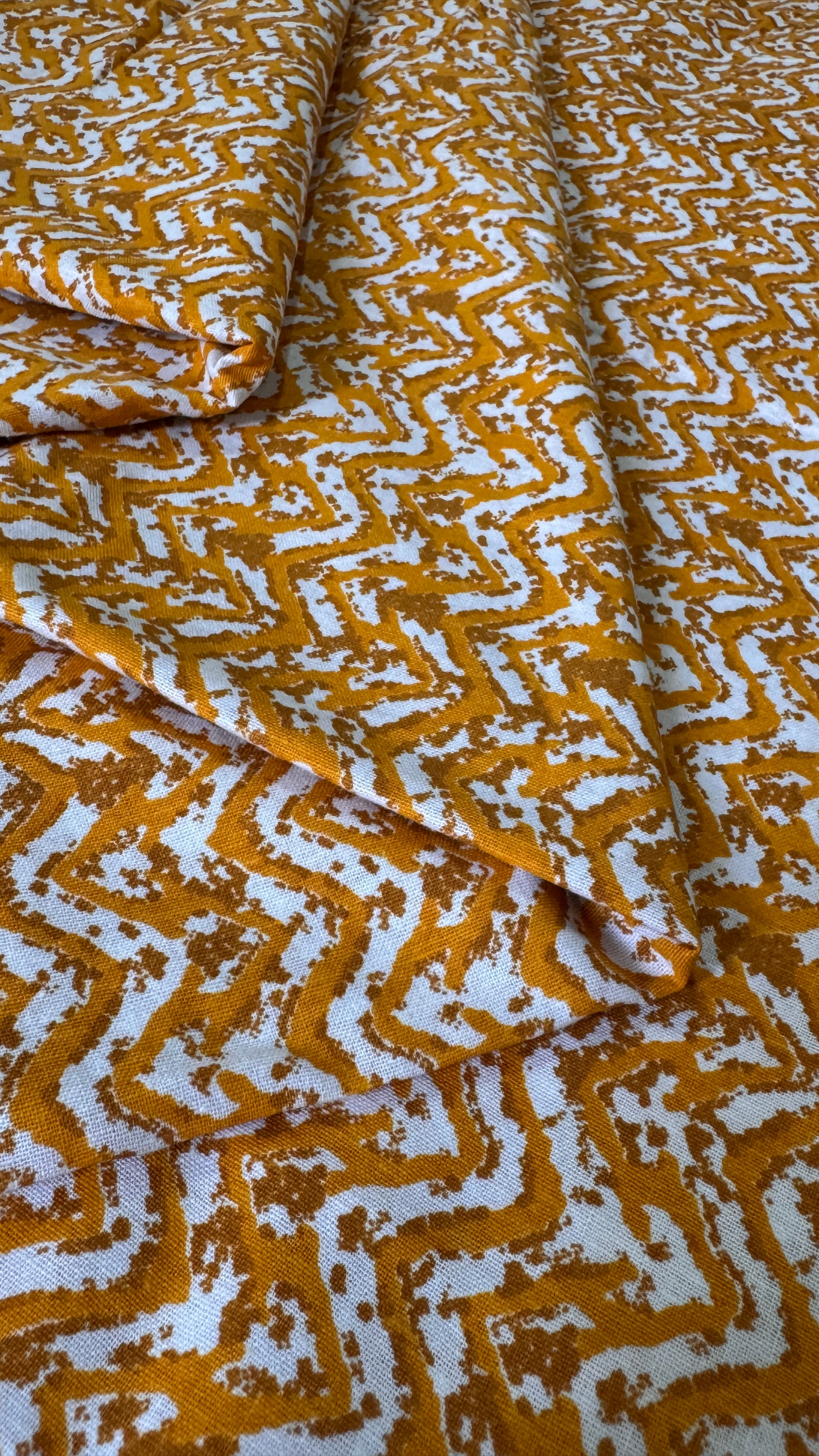 Folded fabric with a yellow and white geometric pattern