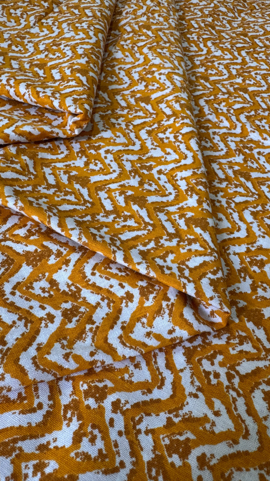 Folded fabric with a yellow and white geometric pattern