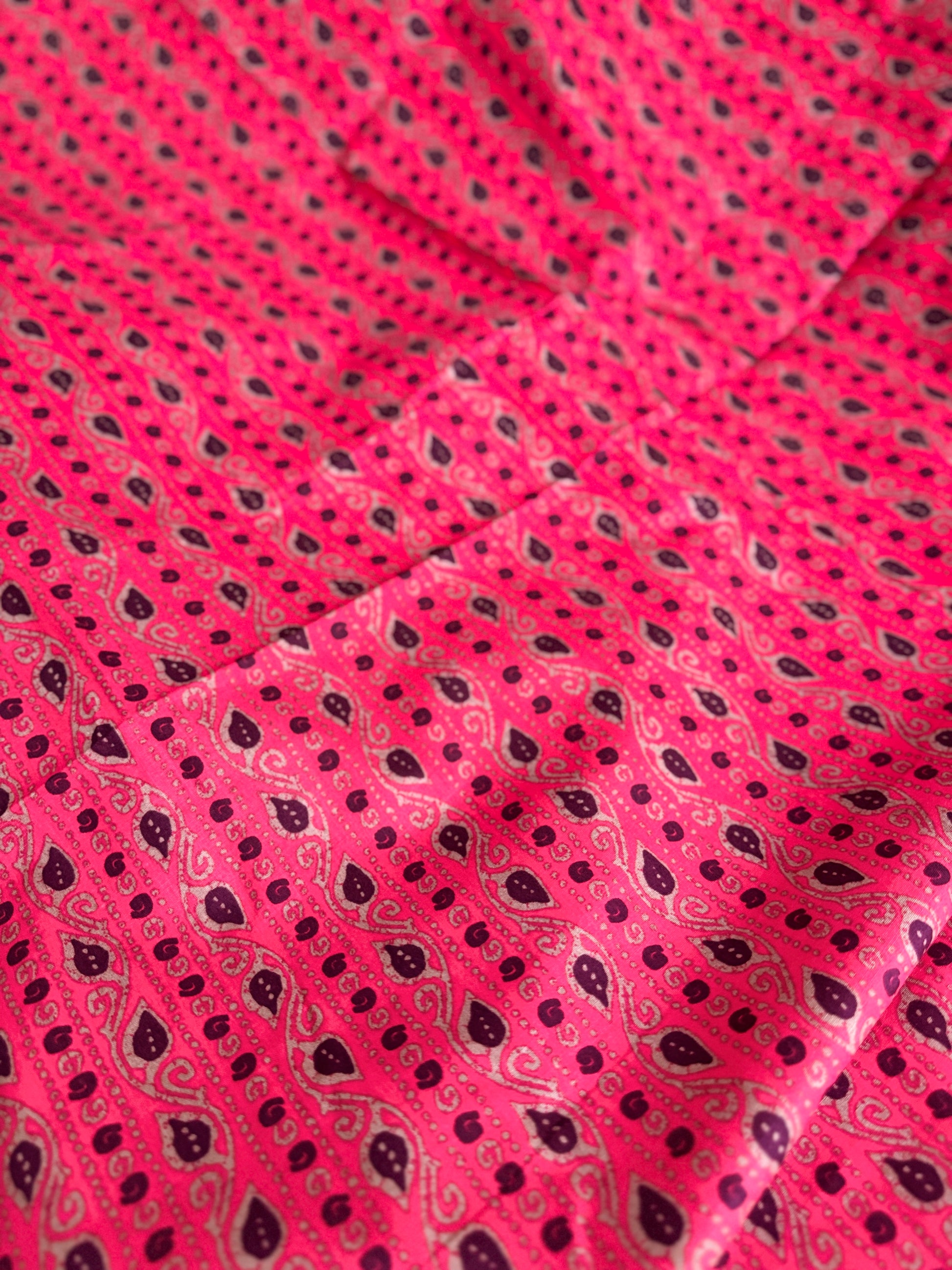 Close-up of pink fabric with black paisley pattern
