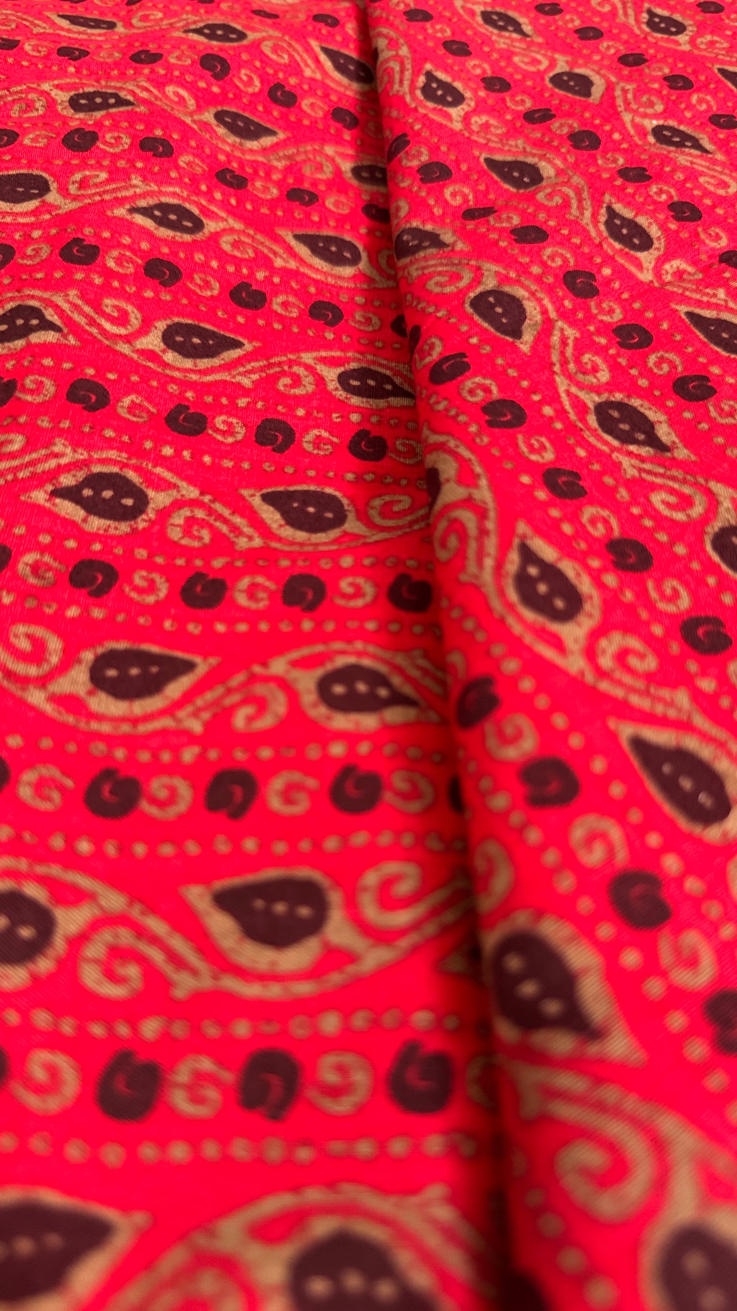 Red fabric with black and gold paisley pattern