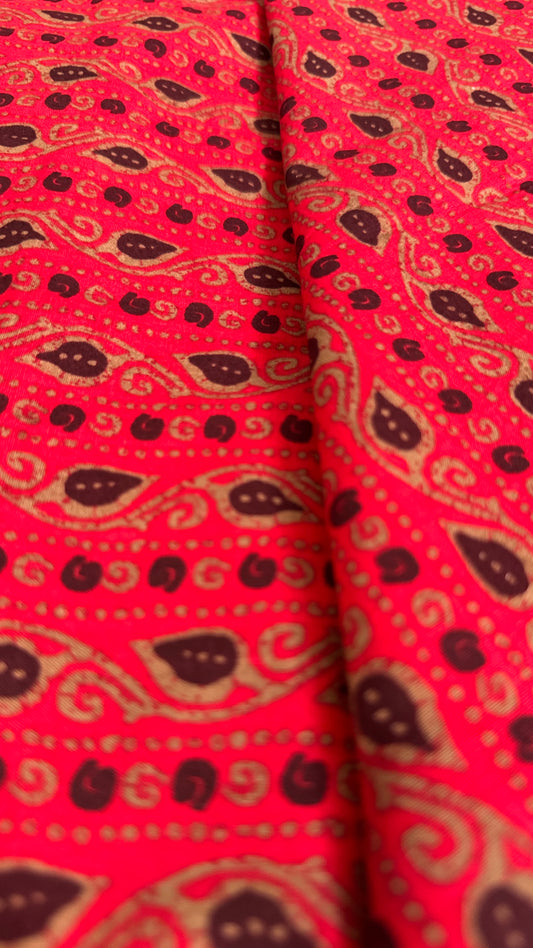 Red fabric with black and gold paisley pattern