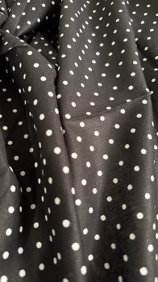 Close-up of black fabric with white polka dots