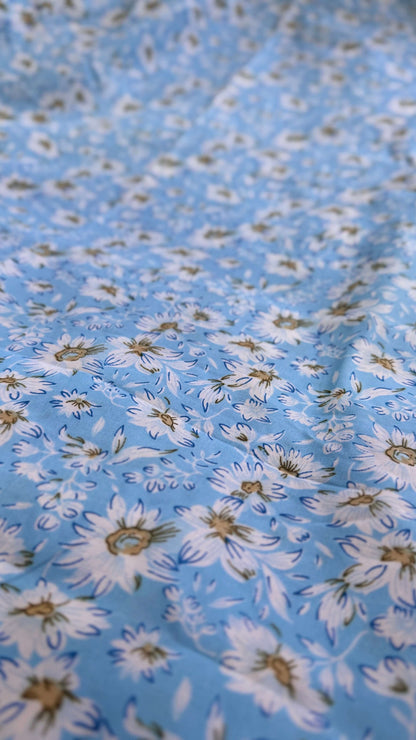 Close-up of floral fabric with white flowers on a blue background