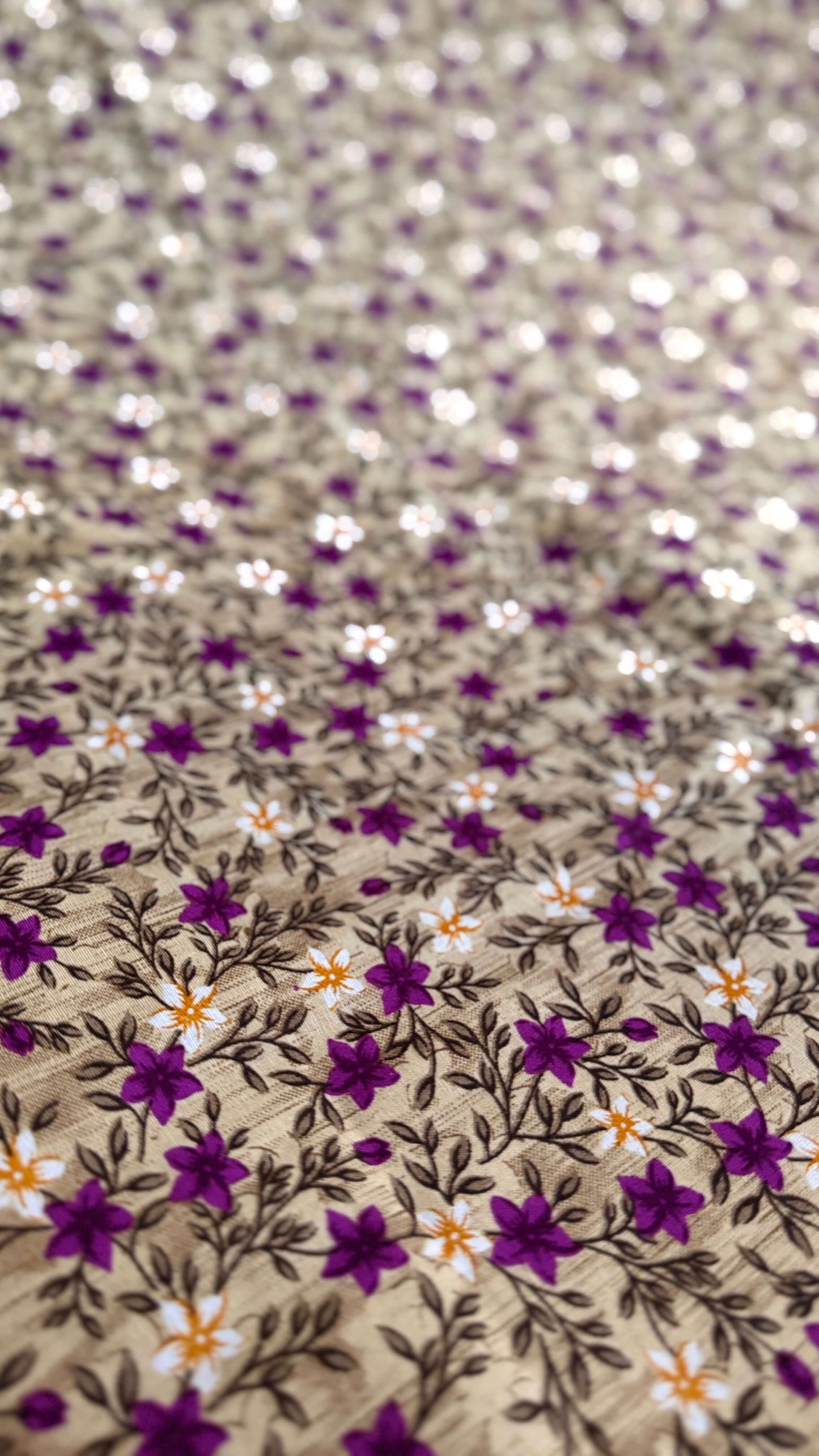 Close-up of a fabric with small floral pattern on a beige background