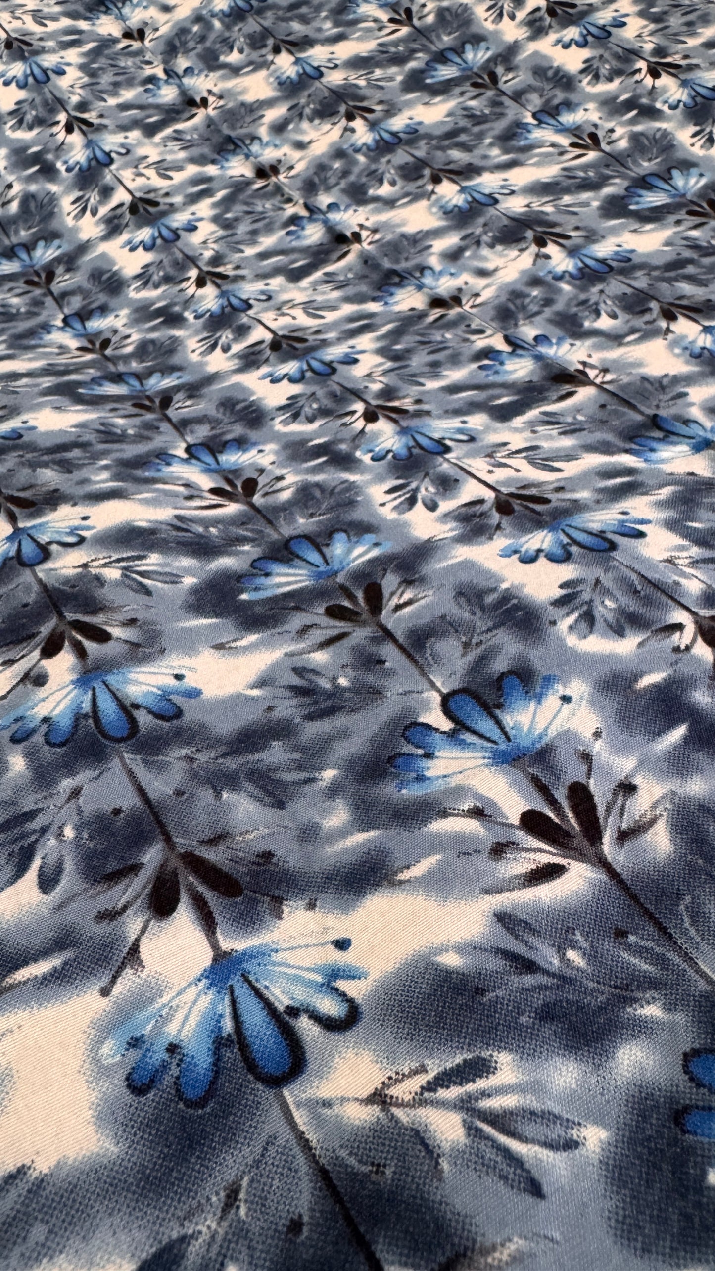 Floral patterned fabric with blue and black flowers on a light background