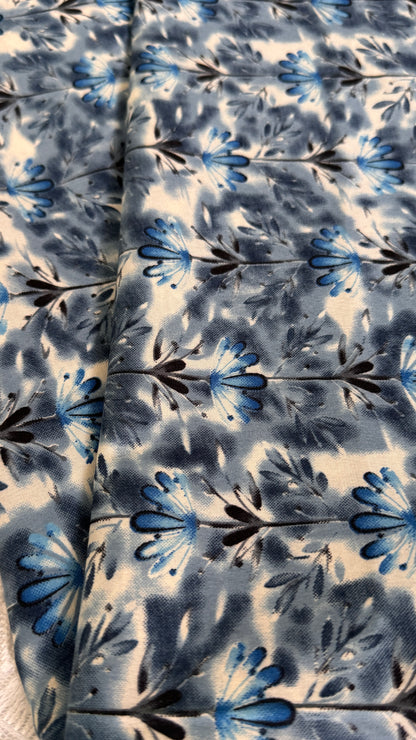 Floral patterned fabric with blue and black flowers on a white background