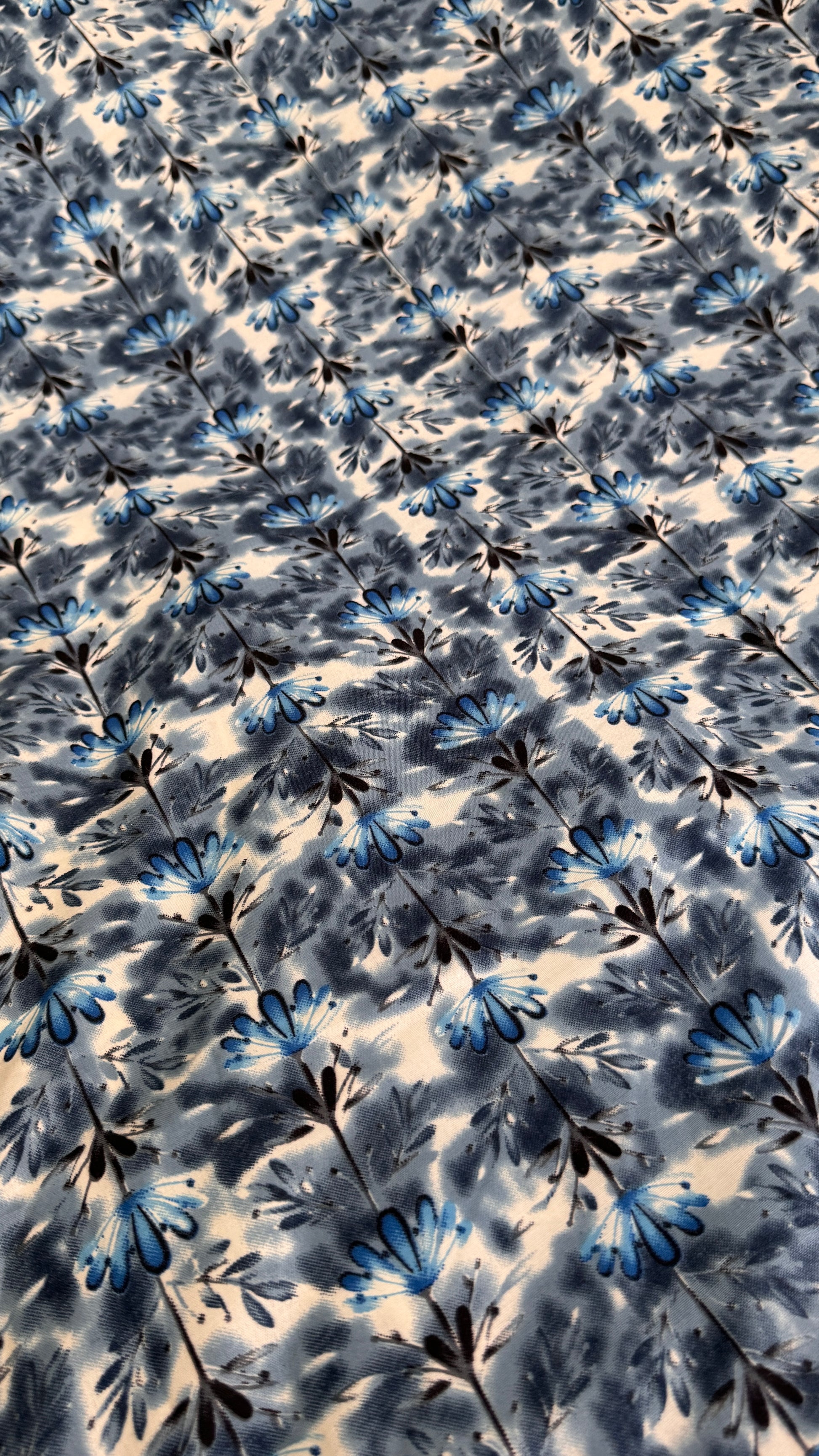 Floral patterned fabric with blue and black flowers on a white background
