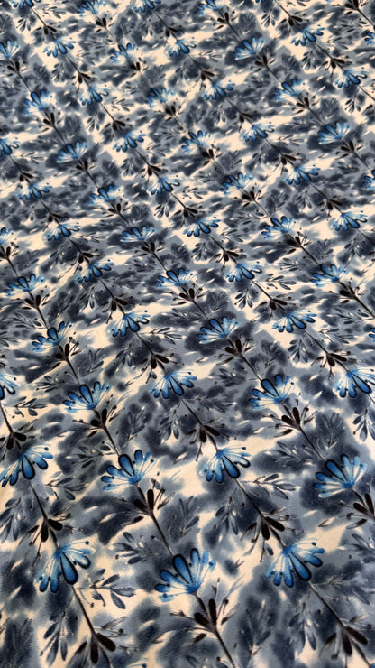Floral patterned fabric with blue and black flowers on a white background