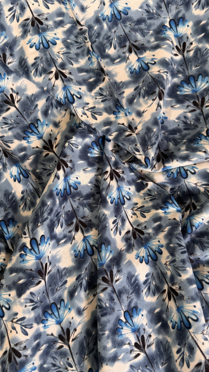 Floral patterned fabric with blue and black flowers on a beige background