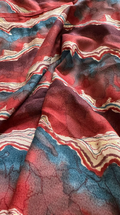 Close-up of patterned fabric with red, blue, and beige colors.