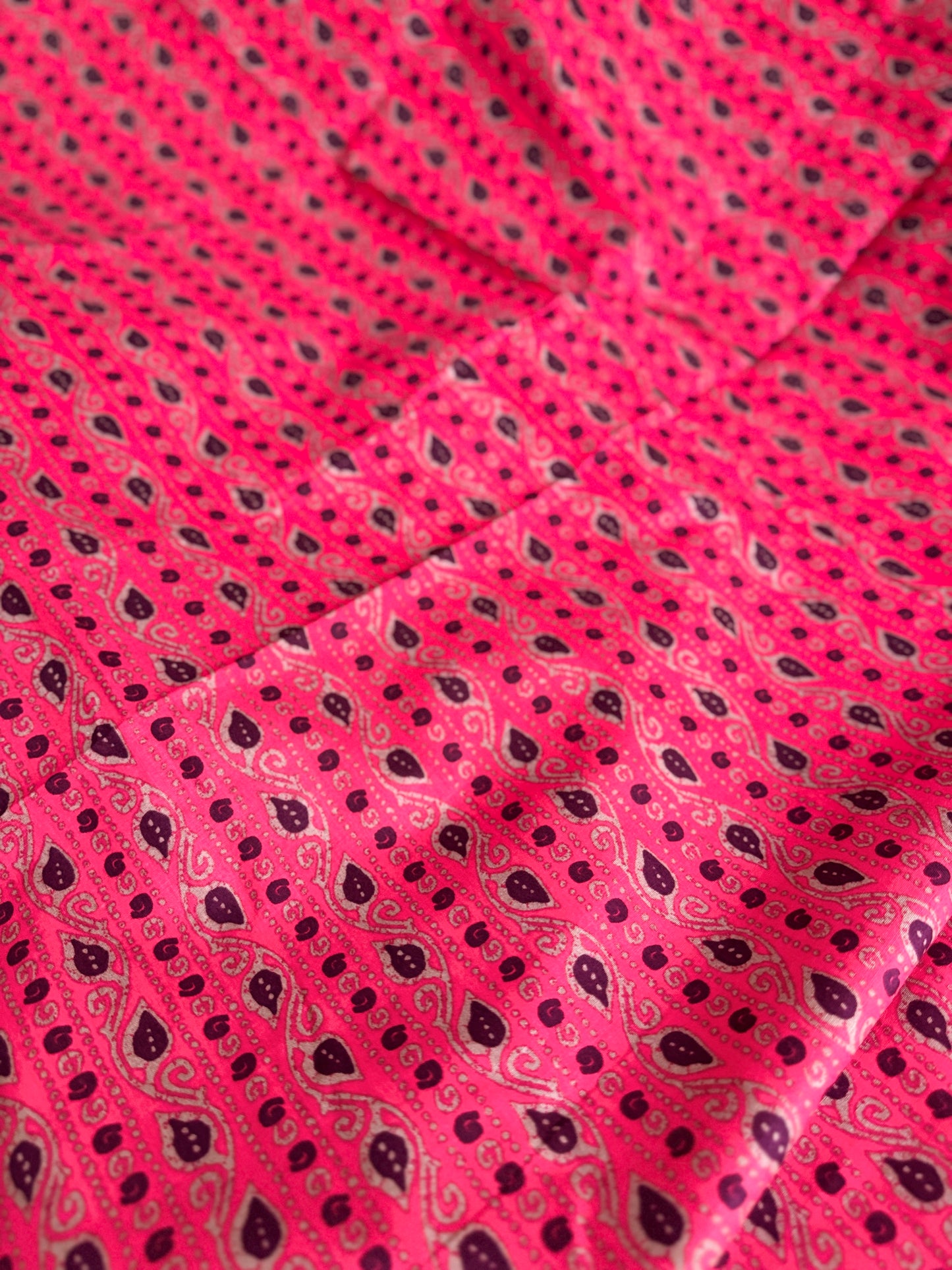 Close-up of pink fabric with black paisley pattern