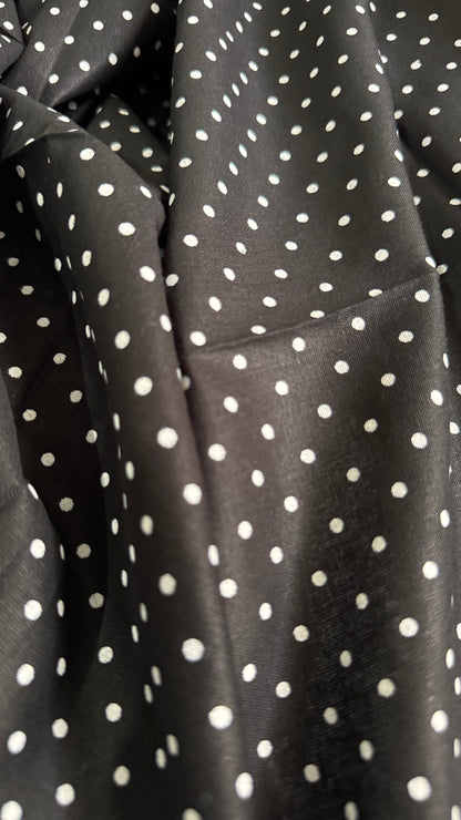 Close-up of black fabric with white polka dots