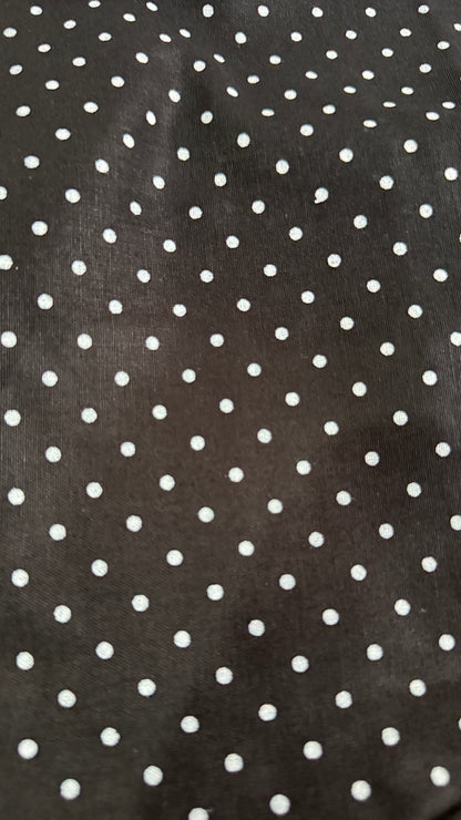 Close-up of black fabric with white polka dot pattern